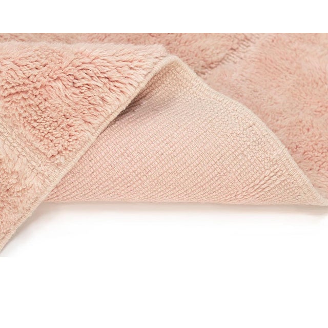 Exquisite hand-knotted wool rug, featuring a stunning fusion of Peach Pink and Melon Pink shades, adorned with understated...