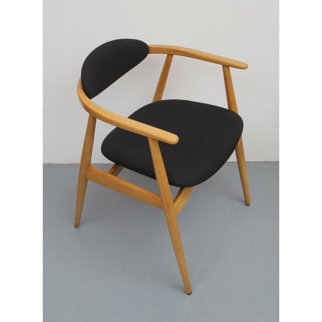 Elegant 60s Armchair, Sleek frame in Bähe bright. The seat and back is newly upholstered and freshly made in black...