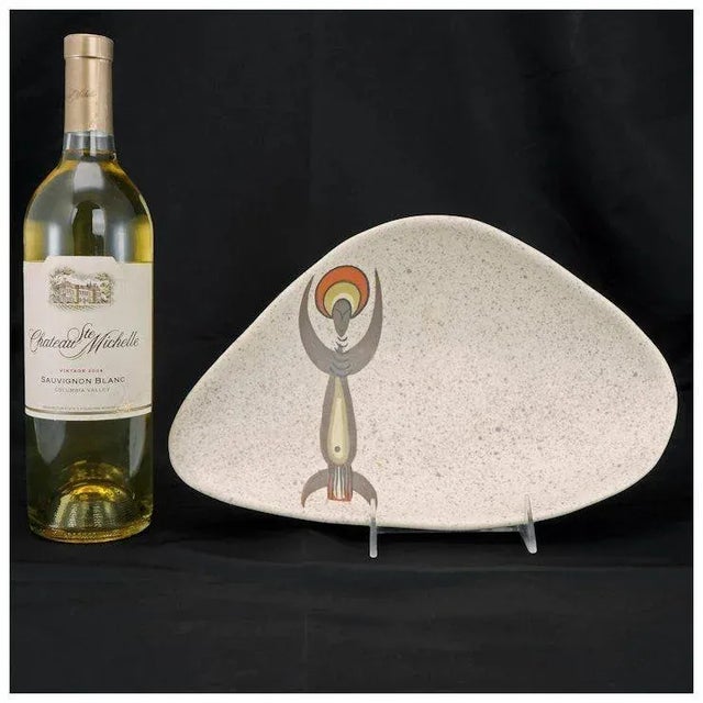 A space age shaped serving dish with a speckled glaze and a hand painted design with an abstract tribal design. It was...