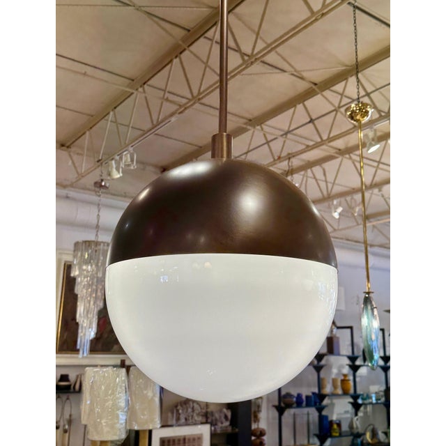 This wonderful Italian bronze and white glass globe shaped pendant light is so classic with its half dome in satin bronze...