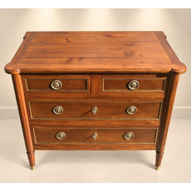 A louis xvi style commode, stamped "gaston boulay 1984," crafted from solid cherry wood with an oak back. it features four...