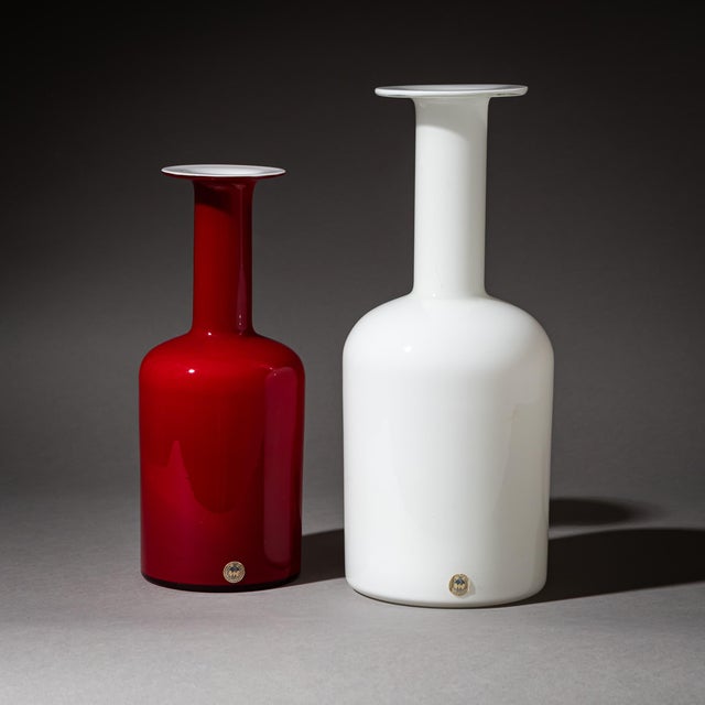 Large and small versions of the “Gulvase” with elongated neck in white opaline glass with a red overlay. Designed by Otto...