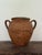 A traditional 19th-century French terracotta pot, once used for storing olives. Features a wide mouth, twin handles, and...