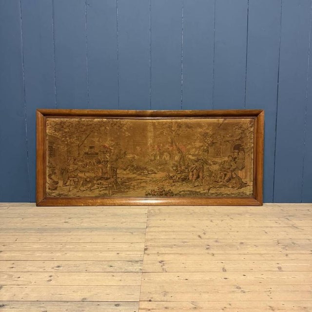 Large woven Gobelin tapestry in a wooden frame from the 19th century. The scene depicts people making music on the left, a...