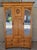 1920's English golden oak armoire with 2 beveled glass mirrored doors. Very nice condition with a glowing mahogany...