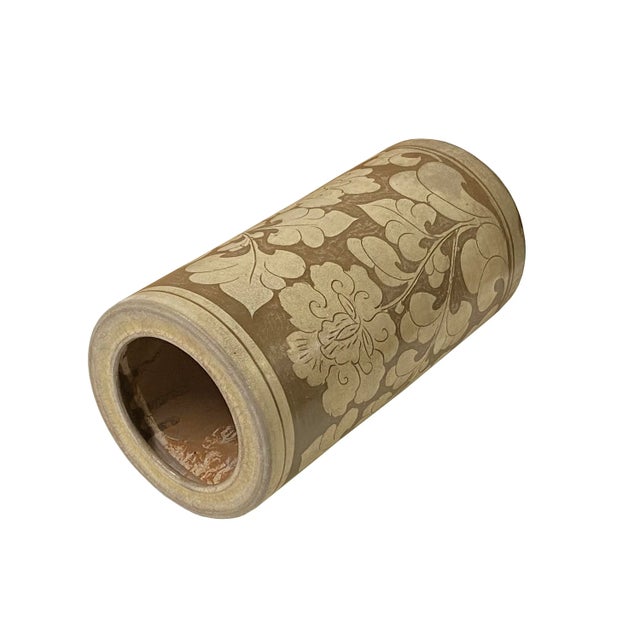 This is a handmade ceramic column shape vase with a flower pattern surface but a vintage distressed tan taupe color...