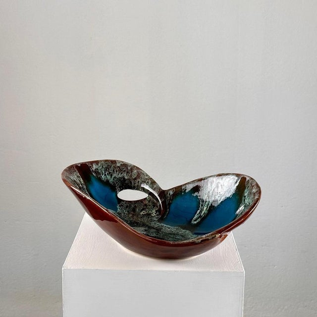 Indulge in the timeless charm of mid-century French craftsmanship with this exquisite enamelled ceramic table center from...