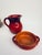 Beautiful vintage Italian ceramic pitcher and handled bowl featuring a rich ruby-red glaze with a warm terracotta...