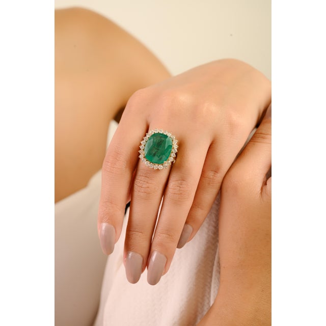 This luxury ring features a large, oval-cut emerald as the center stone, estimated to weigh 9.17 carats, surrounded by a...