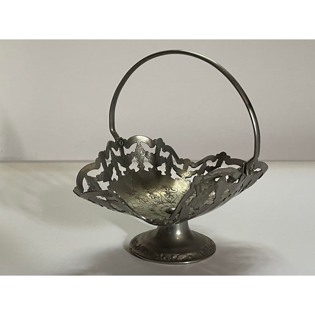 An antique etched cutout silver-plate display basket decorated with scrollwork flourishes.