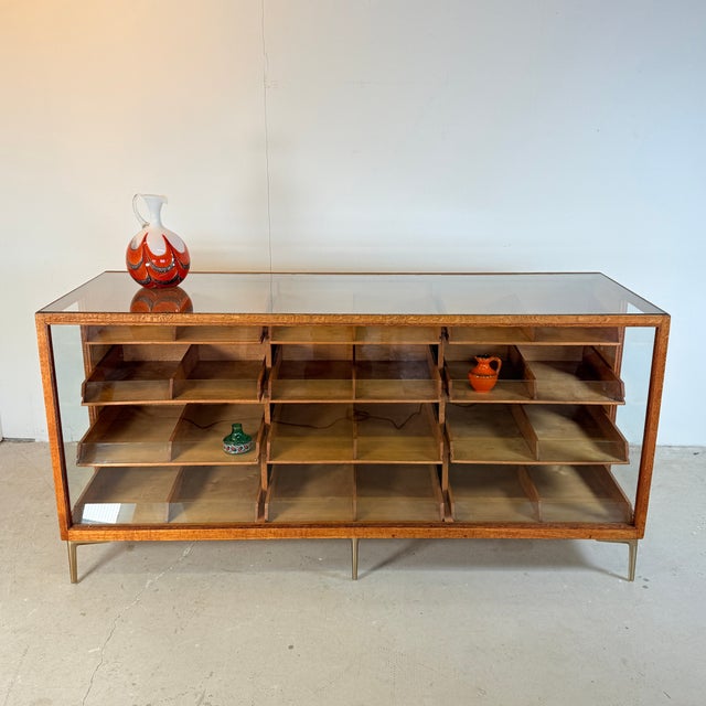 Beautifully crafted counter from the 1960s. The frame is made of solid oak and stands on six gold-colored steel legs with...