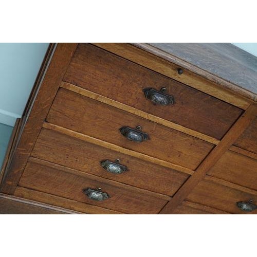 This antique oak shop counter dates from the early 20th century and was made in France. It features an oak paneled frame...