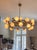 Playful and elegant brass mid-century modern chandelier illuminated by opaque glass bubbles. An object of atomic fascination.