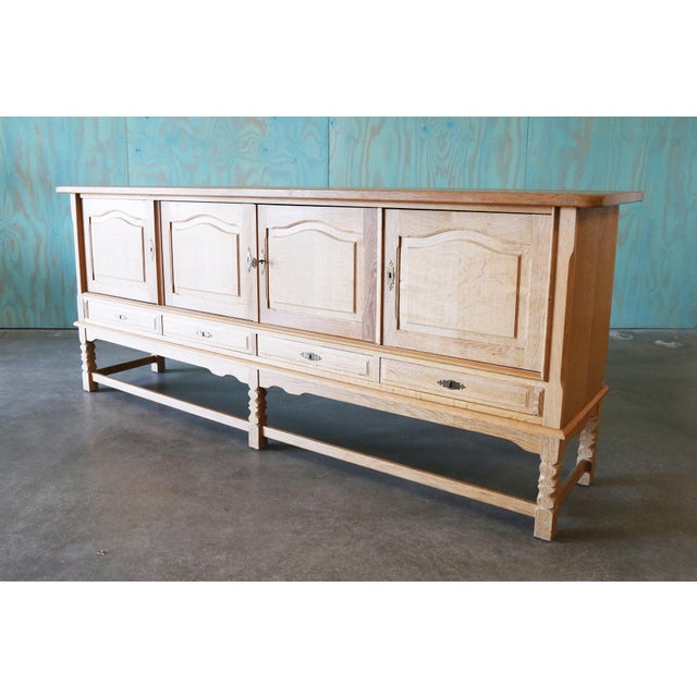 A monumental sideboard cabinet in the style of Henning Kjaernulf, made of solid quarter sawn oak, the rays and checks in...