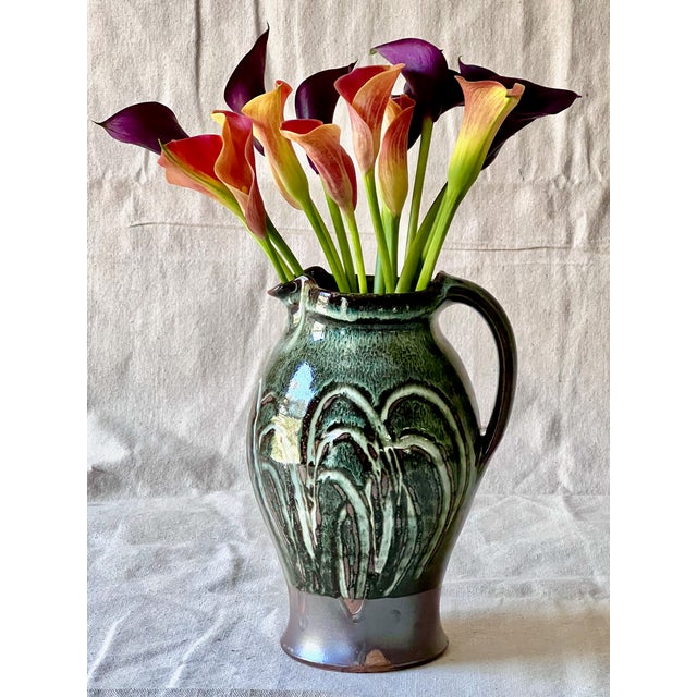 Beautiful hand thrown pitcher by Vermont based potter Eric Moore. A stoneware base with a Vermont wild clay slip and Nuka...