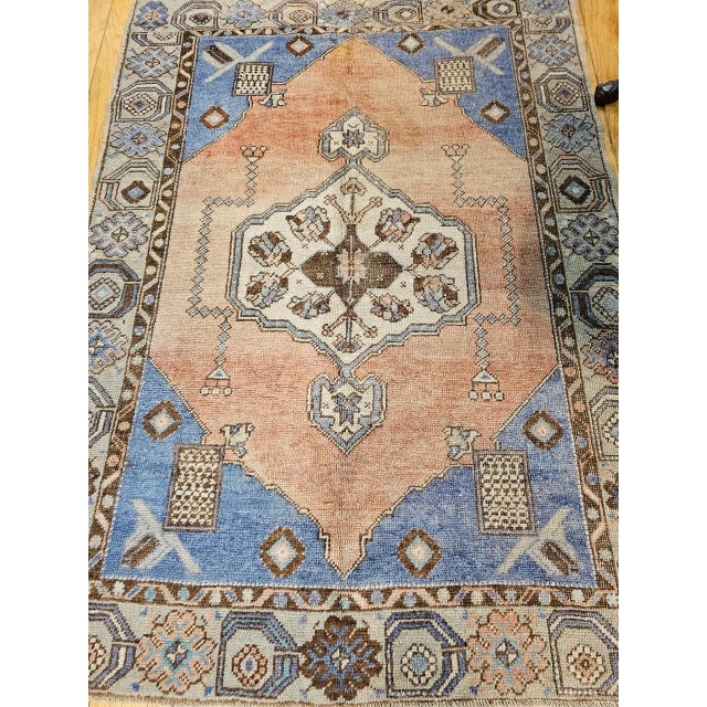 This vintage Turkish Oushak area rug from the second quarter of the 20th century features a striking open medallion design...