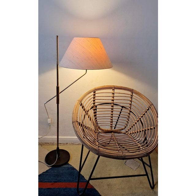 Elegant mid-century brass floor lamp with an iron base, 1950s. The height is adjustable from 74 cm to 166 cm. The lamp...