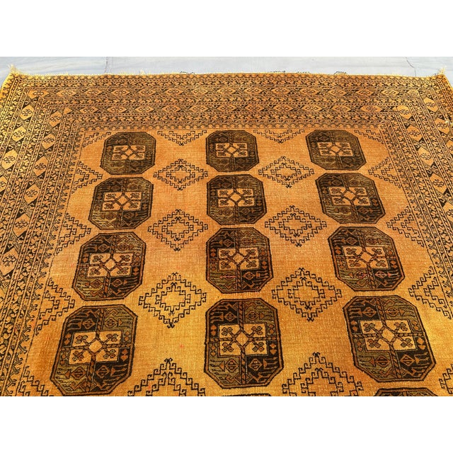 This exquisite vintage Afghan rug, hand-knotted in the 1970s in the renowned Aqcha village of Afghanistan, features the...