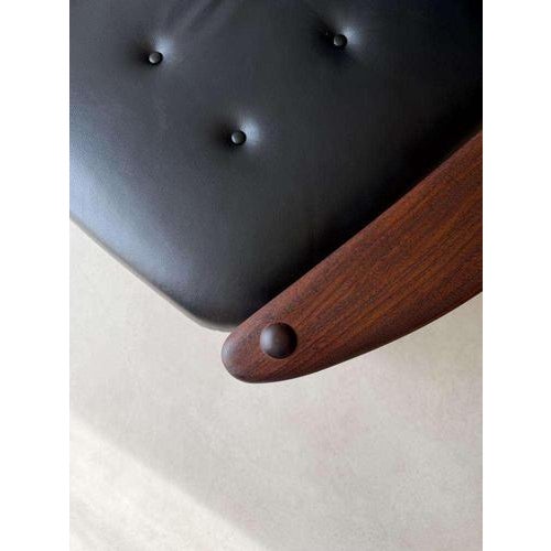 Scandinavian armchair from the 1960s, crafted from solid hardwood and upholstered in black leather. A chair where...