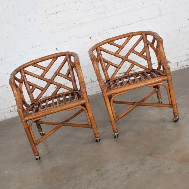 Handsome pair of rattan rolling Chinese Chippendale accent chairs from Wicker by Henry Link. They are in fabulous vintage...