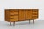 Mid Century Modern Credenza crafted in olive ash wood and African teak, c. 1960’s. The cabinet features a stunning pair of...