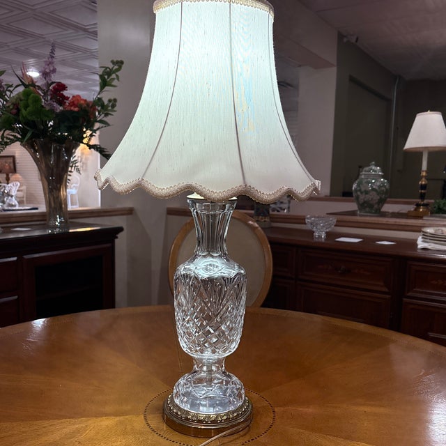 An elegant Waterford crystal table lamp featuring a tall urn-form base with a sophisticated mix of deep diamond cutting on...