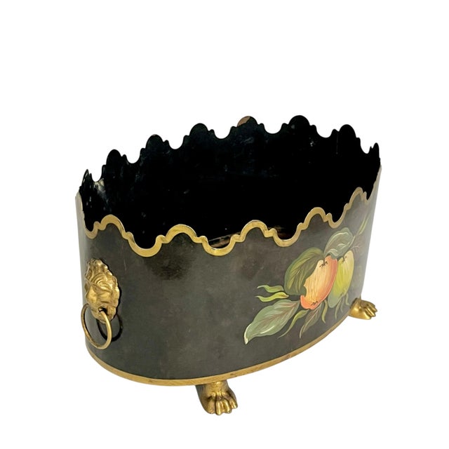 A striking vintage French tole cachepot by Maison Lancel, featuring a dramatic black ground, a scalloped rim accented with...