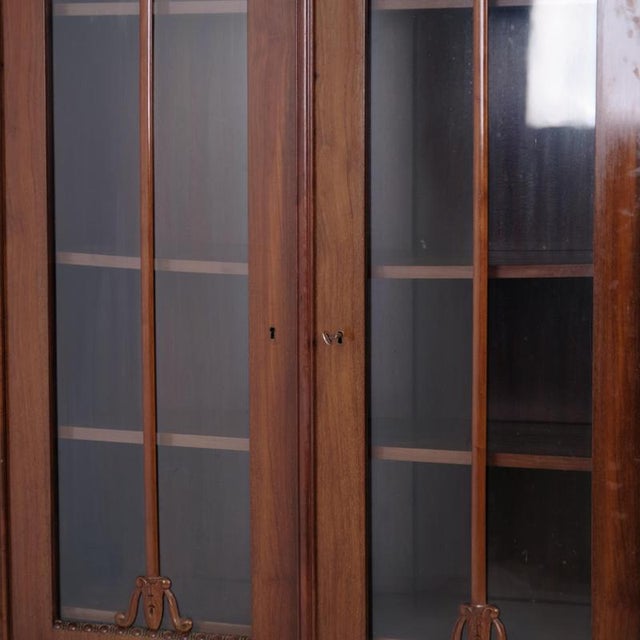 Antique display cabinet crafted from hand-polished mahogany with glass doors. The cabinet was made in the 19th century in...