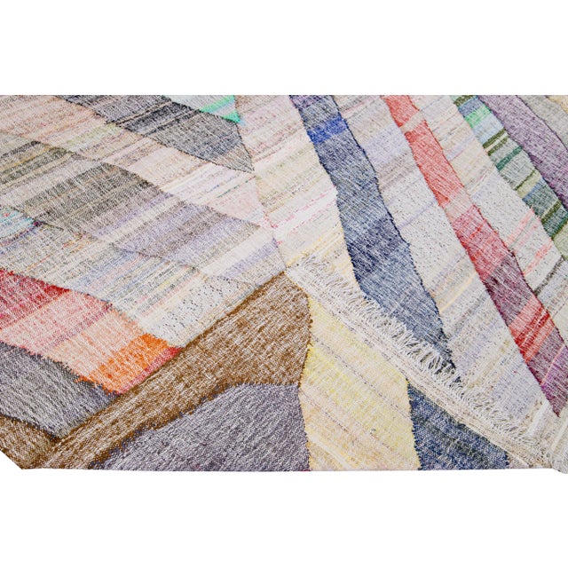 Beautiful vintage Kilim flatweave wool rug. This Turkish rug has a multicolor field featuring a gorgeous all-over...