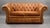 A quality traditional Chesterfield two-seater sofa, upholstered in beautifully coloured tan leather with a rich, warm...