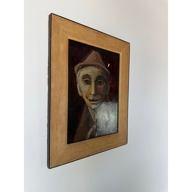 A haunting and emotionally charged portrait, this 1960s vintage oil painting depicts a clown figure rendered in an...