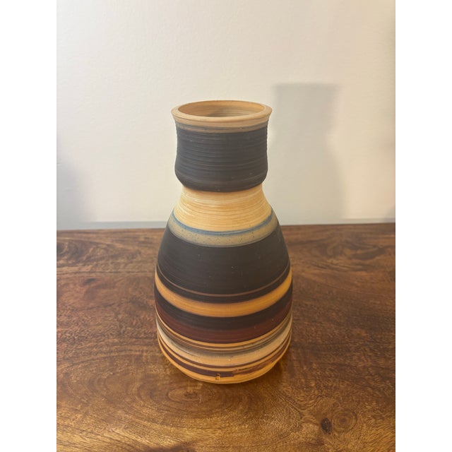 A late 20th century studio stoneware vase featuring a grounded earthtone palette. The form is clean and balanced, wrapped...