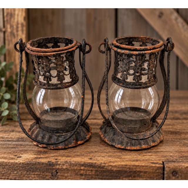 Striking pair of circa 1920s iron and glass candle lanterns featuring ornate pierced metal galleries, clear rounded glass...