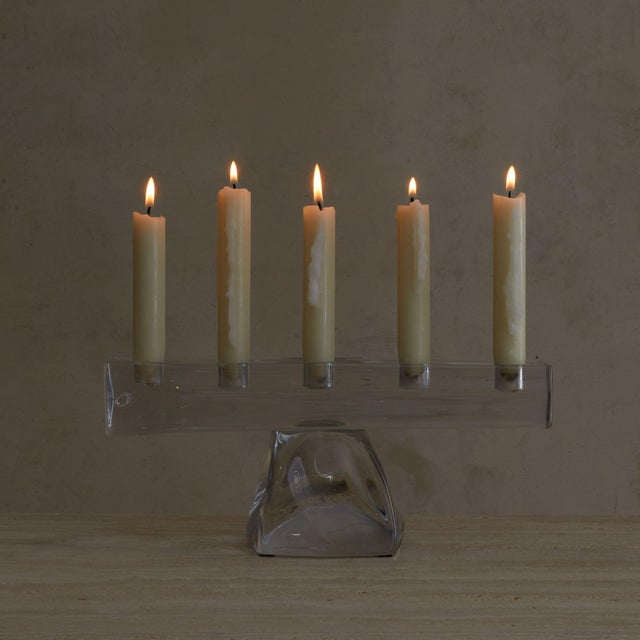 A French crystal candelabra from the 1960s, in the manner of Daum. A molten, rock-like base rises into a linear bar cut to...