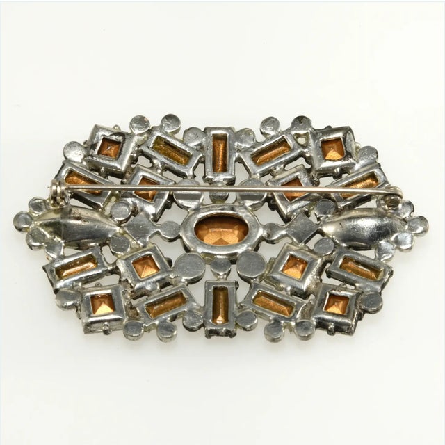 Vintage brooch decorated with clear rhinestones in varying shapes and sizes set in pot metal. A great example of 1930s...