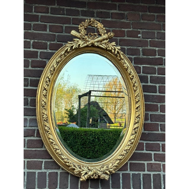 Add refined French elegance to your interior with this beautiful oval wall mirror, crafted circa 1960. With its antique...