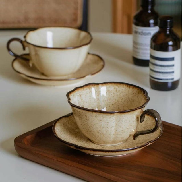 Crafted using handmade earthenware techniques, the cups and saucers feature natural beige-brown speckled textures. The...