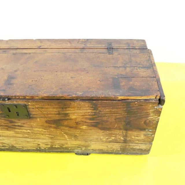 Rectangular wooden chest with a numbered metal lock.