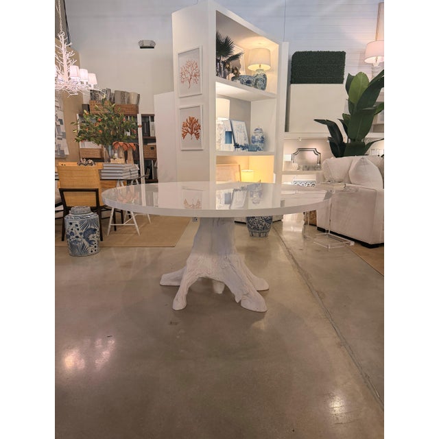 Beautiful 60" round resin dining table featuring a glossy frost white top and a sculptural faux bois driftwood-style...