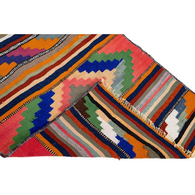 Beautiful vintage Turkish Kilim hand-knotted wool rug with an orange field. This piece has multicolor accents in an all-...