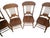 Classic set of four vintage solid oak dining chairs featuring beautifully carved pressed-back crest rails, turned spindle...