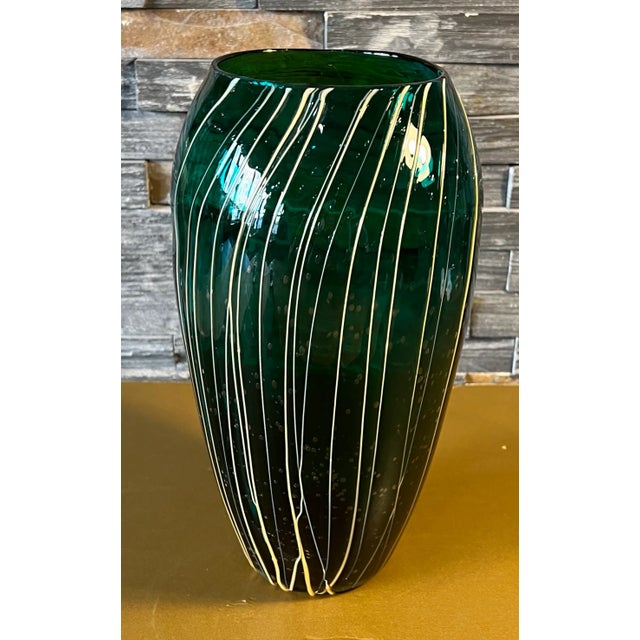 Standing att 11 inches tall, this hand-blown art glass vase was crafted from captivating emerald green glass, it boasts a...