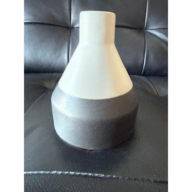 Sculptural ceramic vase by West Elm featuring a softly textured ivory-white upper body and contrasting charcoal gray base....