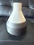 Sculptural ceramic vase by West Elm featuring a softly textured ivory-white upper body and contrasting charcoal gray base....