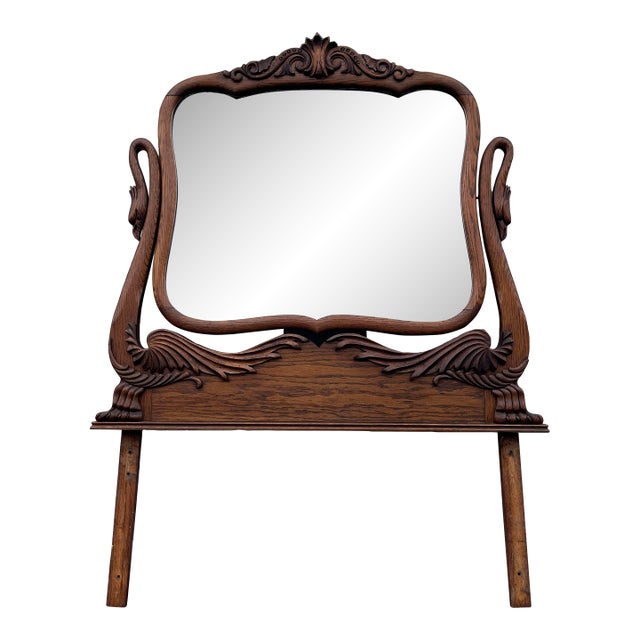 An early American dressing mirror from the early 1900’s. Features an articulating design with carved swans on either end....