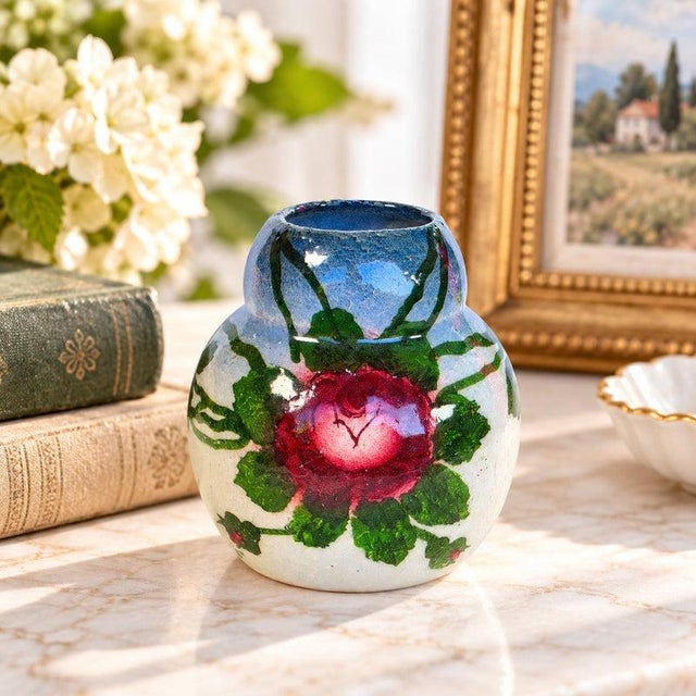 Charming petite vintage art pottery vase featuring hand-painted floral decoration and a beautifully aged, extensively...
