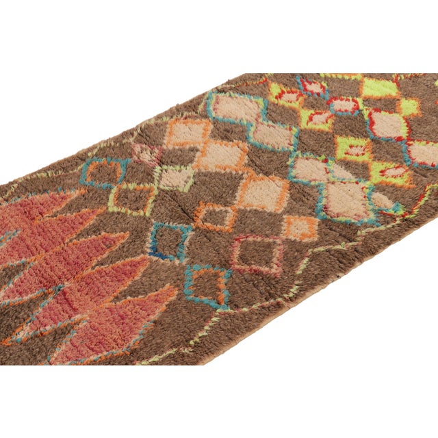 Hand-knotted in wool and originating from Morocco circa 1950-1960, this 3x7 vintage runner rug is a rare and among the...