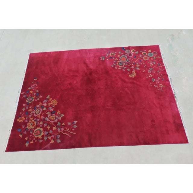Deep red field Chinese Deco Nichols rug. Bright colored floral design in two corners. One or two small discolorations...
