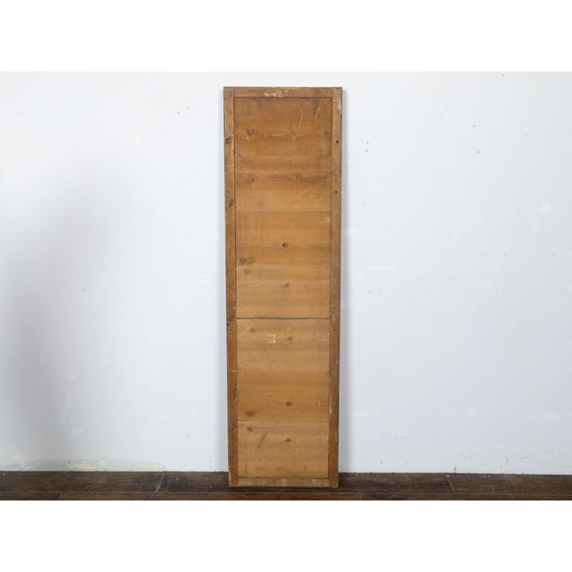 A French Turn of the Century tall and narrow giltwood mirror from circa 1900 with split glass panels and carved frame....