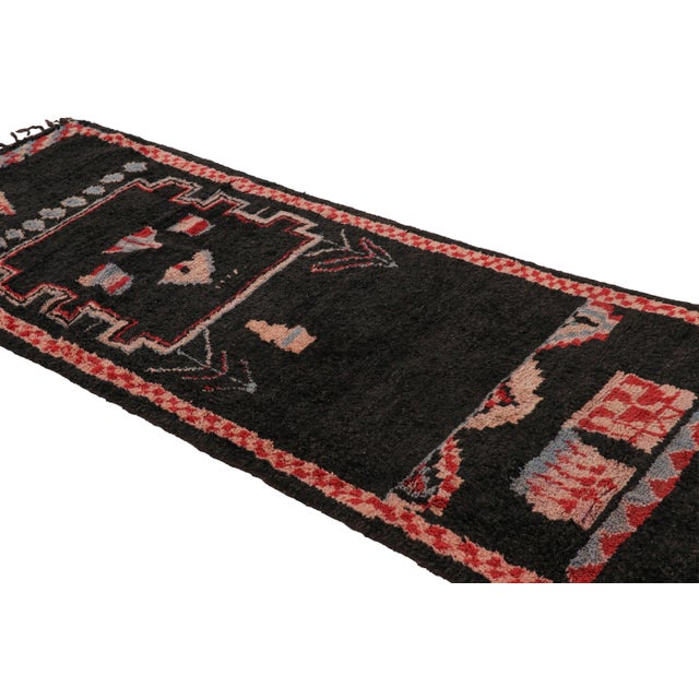 Hand-knotted in wool and originating from Morocco circa 1950-1960, this 4x10 vintage Moroccan rug is an extremely rare...